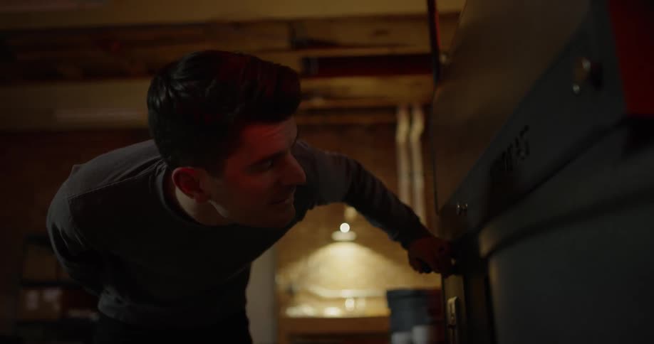 Man checks out device in a dark room at night