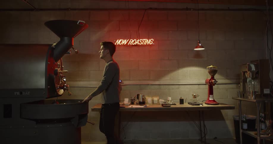 Man stands by industrial coffee machine in shop