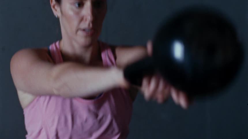 A woman swinging a kettlebell
