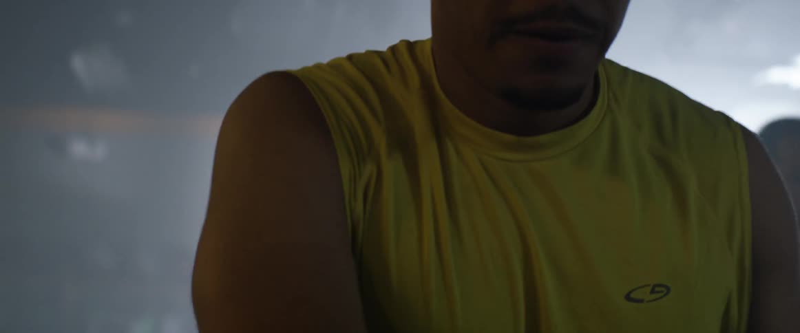 Man wiping sweat off his face with his shirt