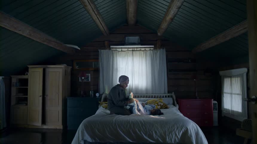 Mother and daughter sit on bed together