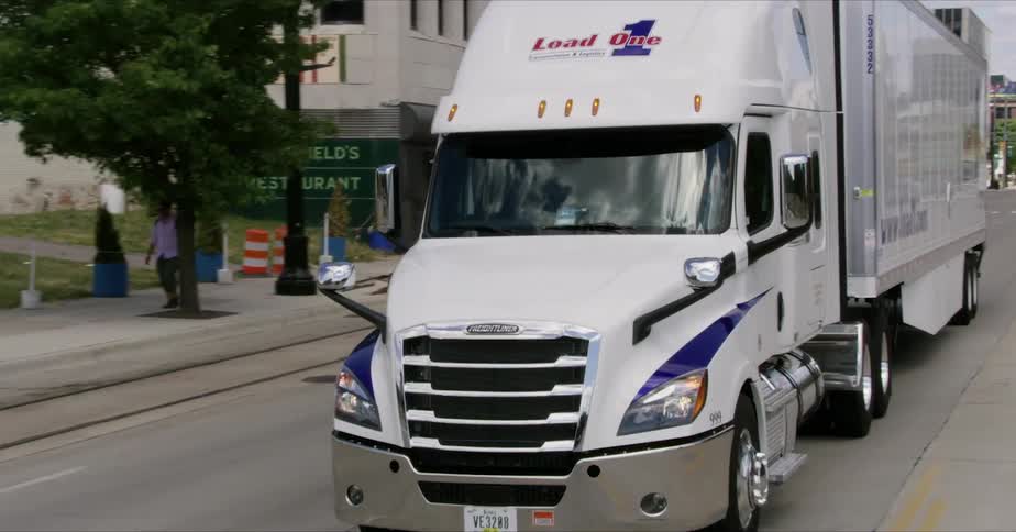 Semi truck drives down a city street