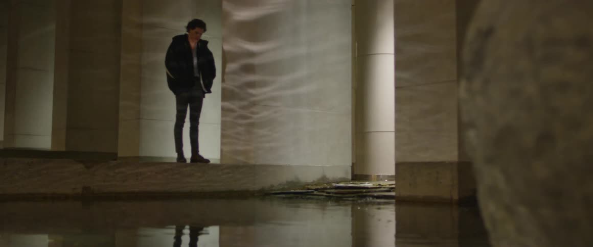 Hey man looks at the water with his hands in jacket pocket