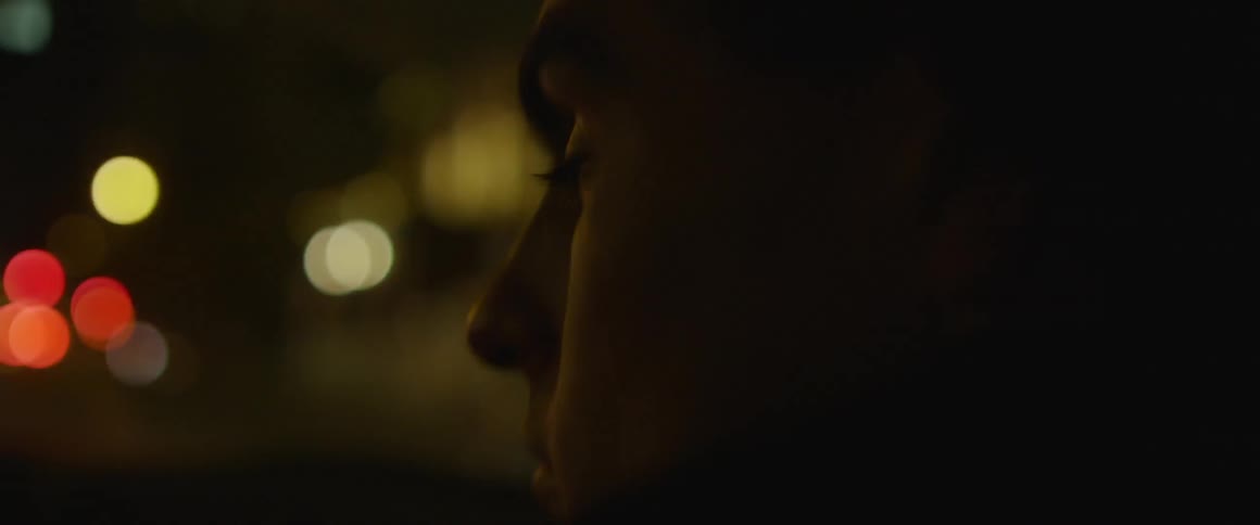 A man rides in a car at night