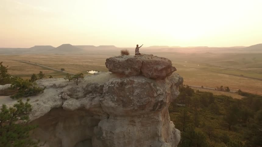 A scenery of man worship above a big rock