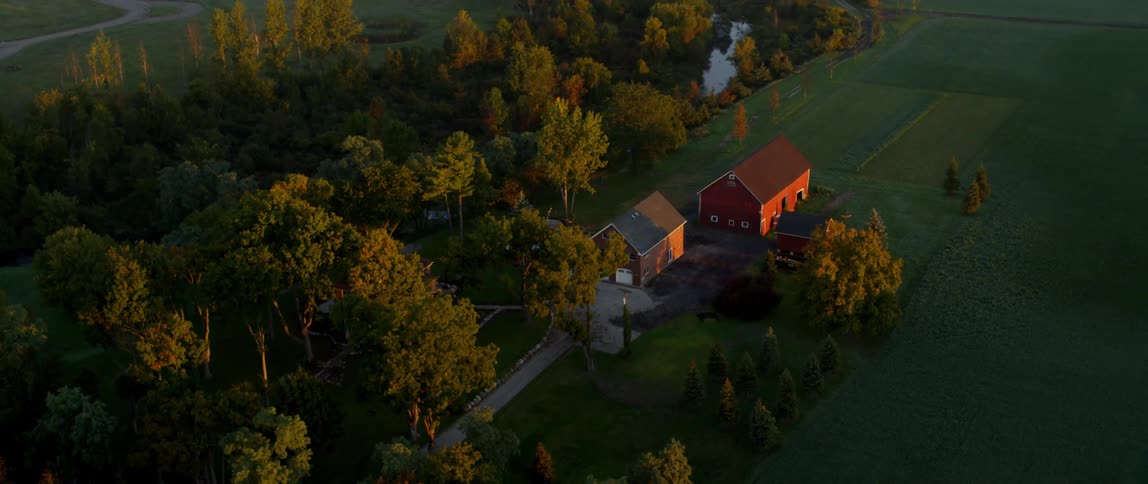 The farm is lined by a brook and trees