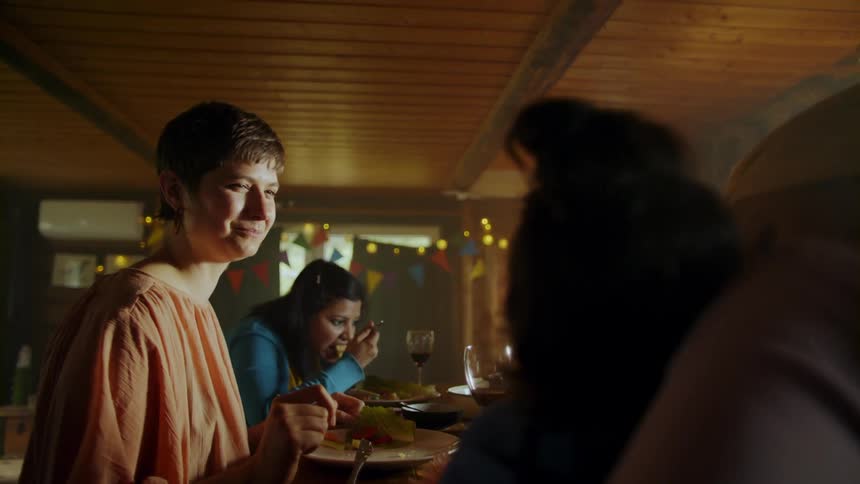 Two young women and a child are sitting at a table with bunting lining the walls