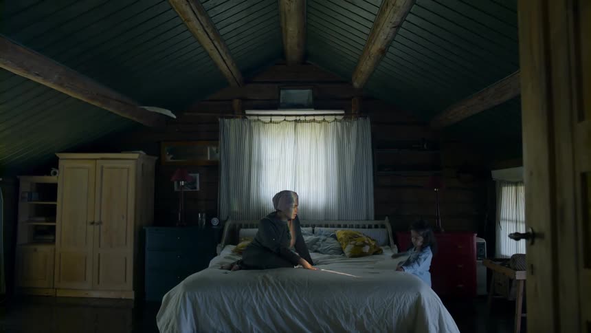 A woman and a young girl read a book on a bed and then the girl puts the book back on the shelf