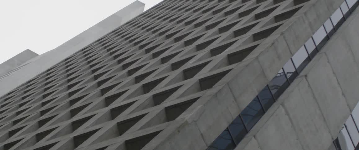 The tall building reaches into the cloudy sky