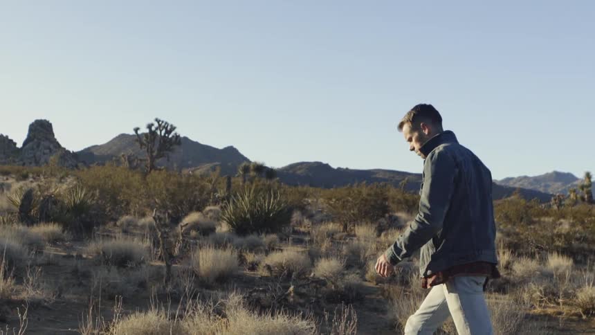 A man hikes in the desert on a sunny day