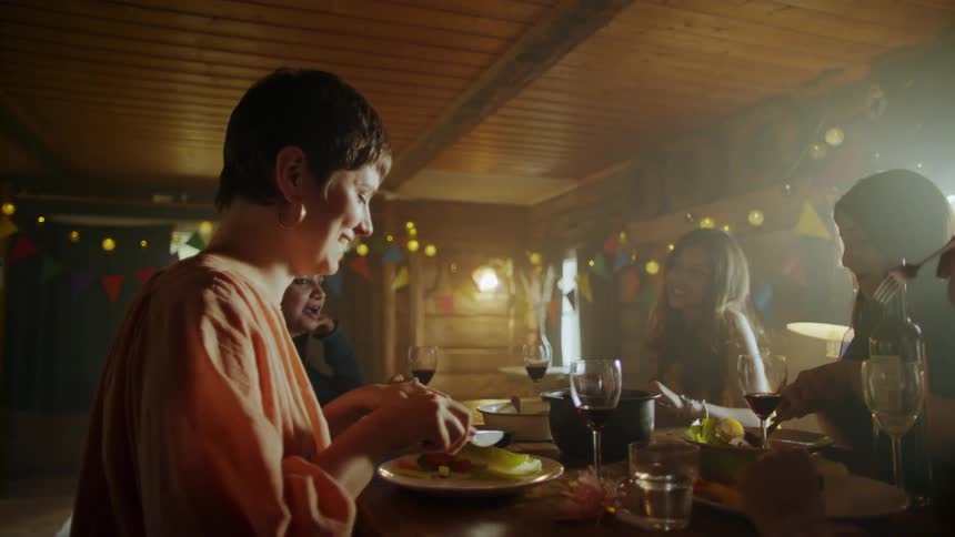 People eat and laugh at a party