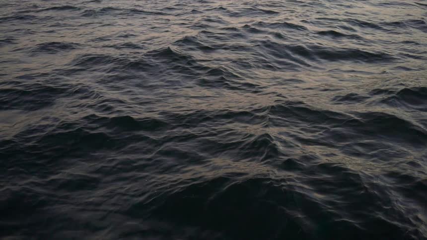 Choppy blue sea at sunset