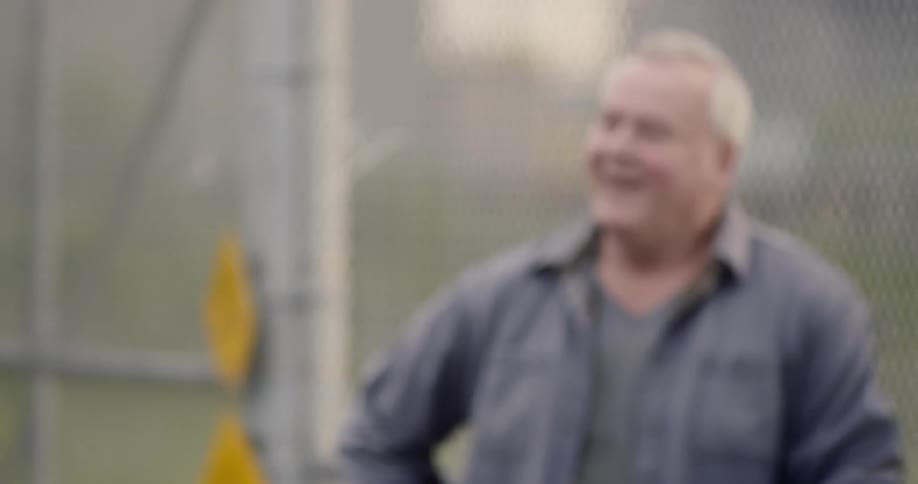 A young man walks away as an older man looks on and laughs
