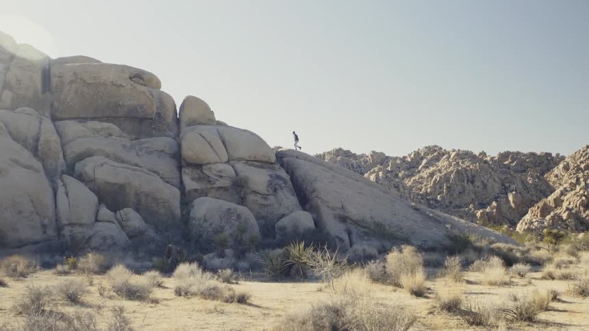 A man scrambles up a set of rocks at speed