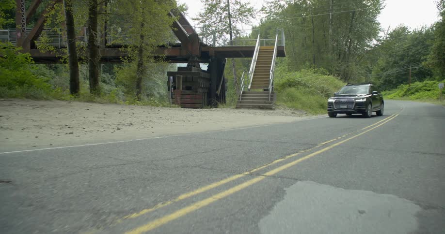 A vehicle drives down the road before parking