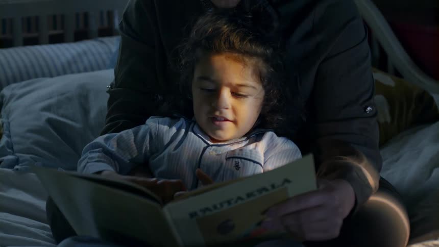 A person with a child and book in their lap
