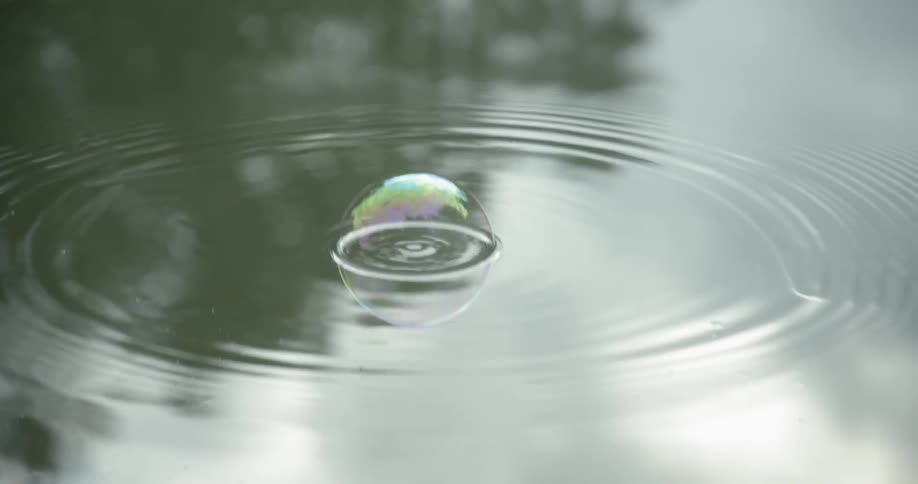 Raindrops fall into a puddle