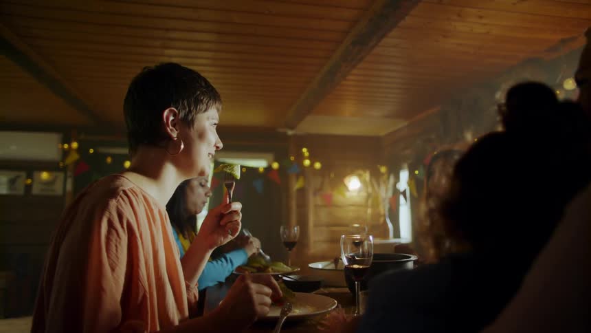 Several women sit at a table eating and laughing