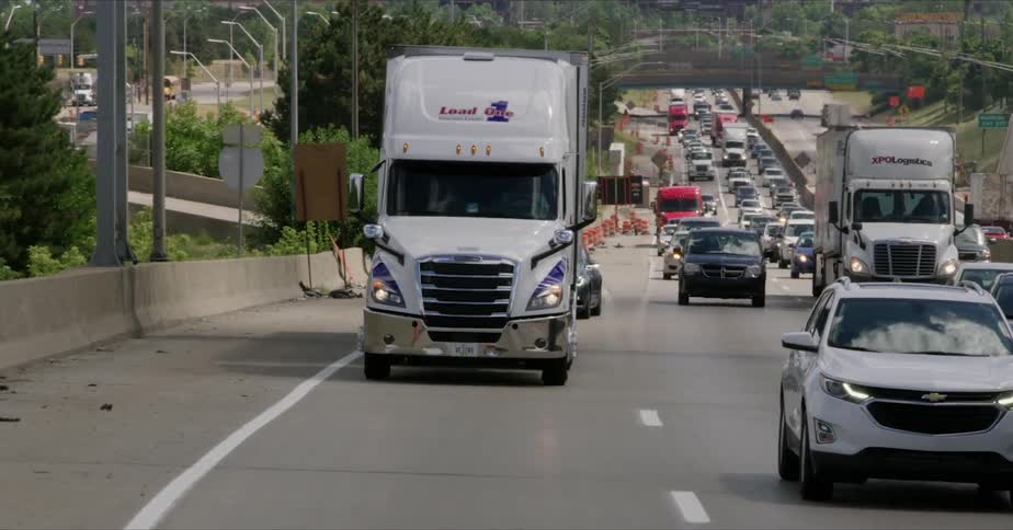 Semis and cars travel on a city highway