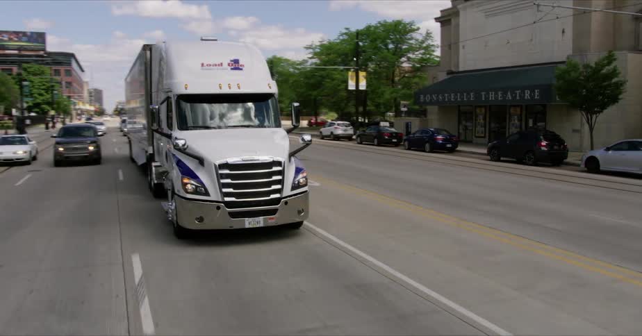 A semi truck is driven on a city street