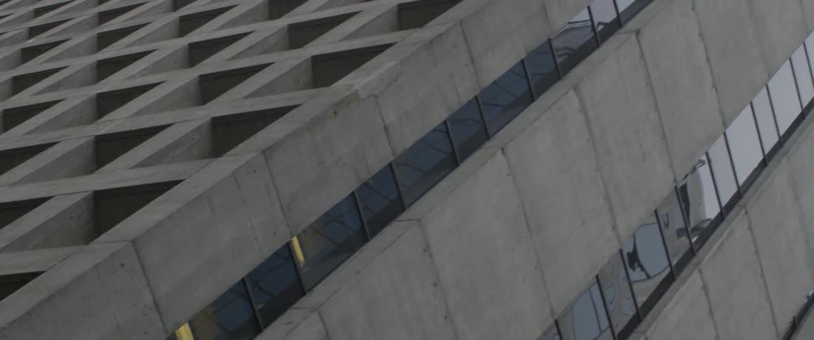A concrete building with evenly spaced square holes for windows