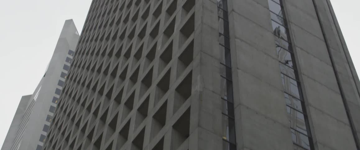 A concrete city building with several floors on a cloudy day