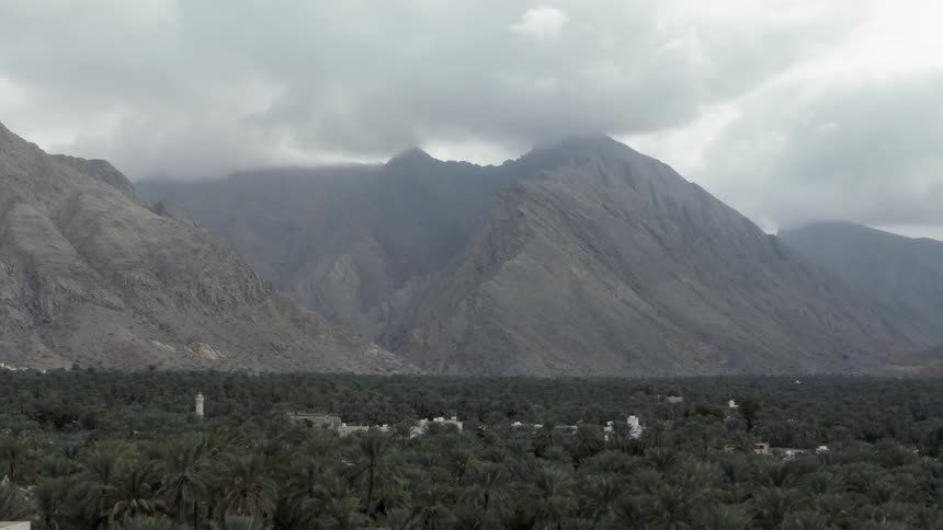 A tropical forest lies beneath misty mountain tops