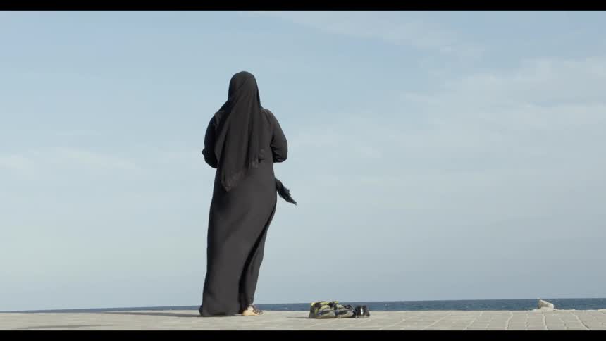 The wind moves an Arab woman's long tunic