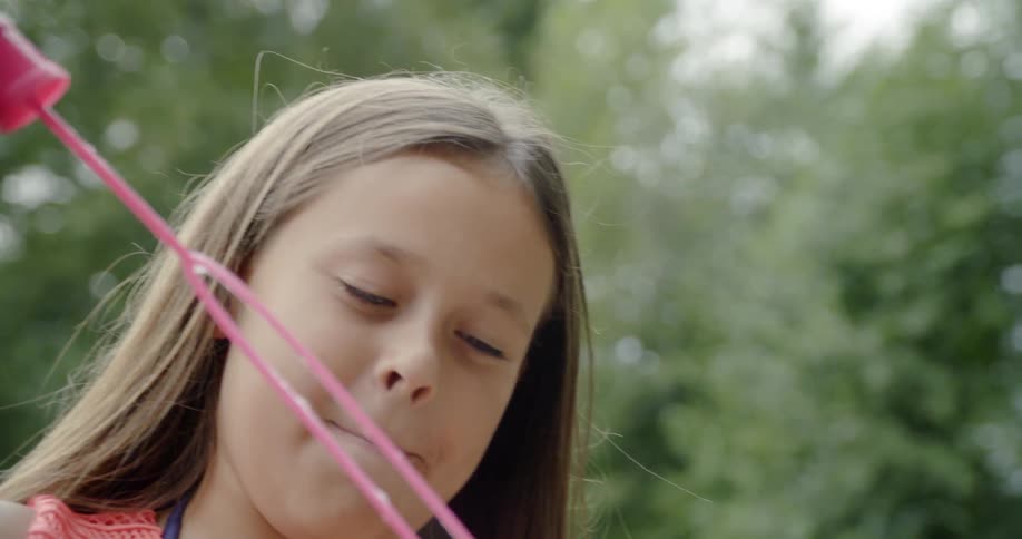 A girl plays with bubbles in the yard