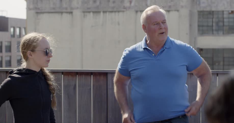 Man talks to teenagers near short fence