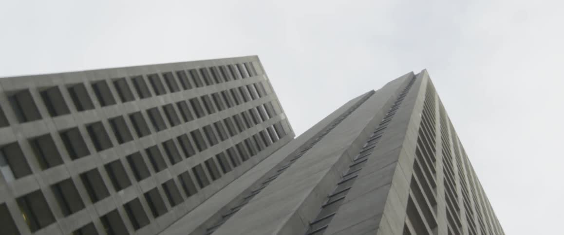 The tall building has many windows on a cloudy day