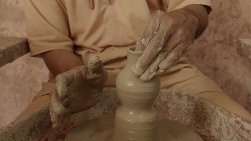 Close-up of a man creating pots from clay
