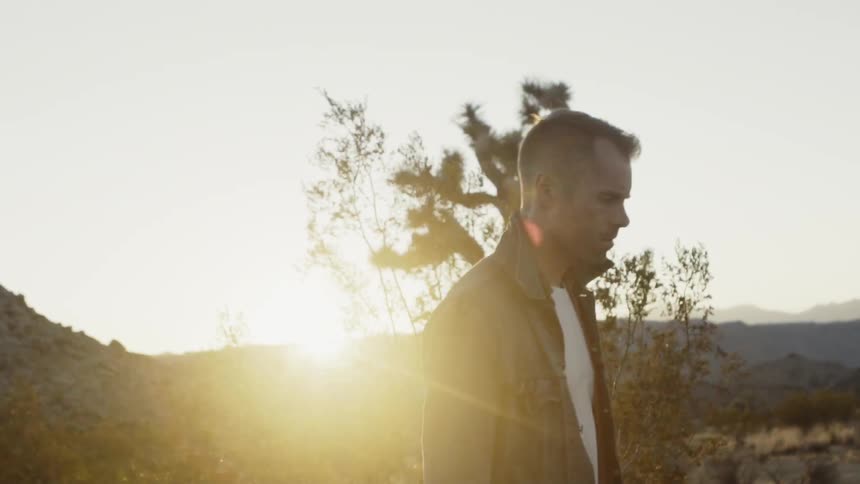 A man is walking outside when the sun sets