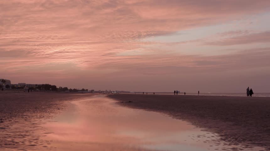 People are by the beach when the sun sets