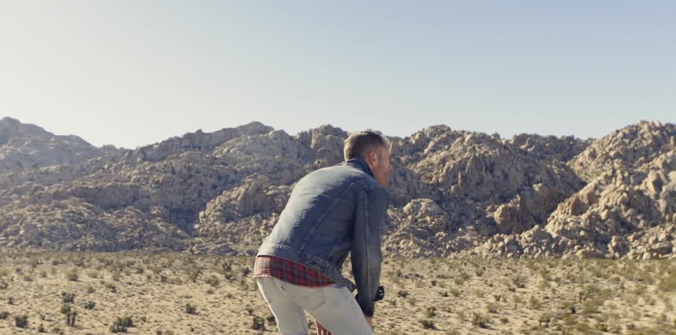 A man is sitting down in a desert area