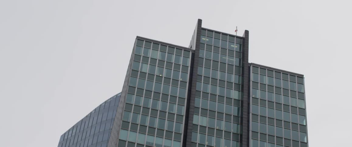 A flag sits at the top of the very tall building