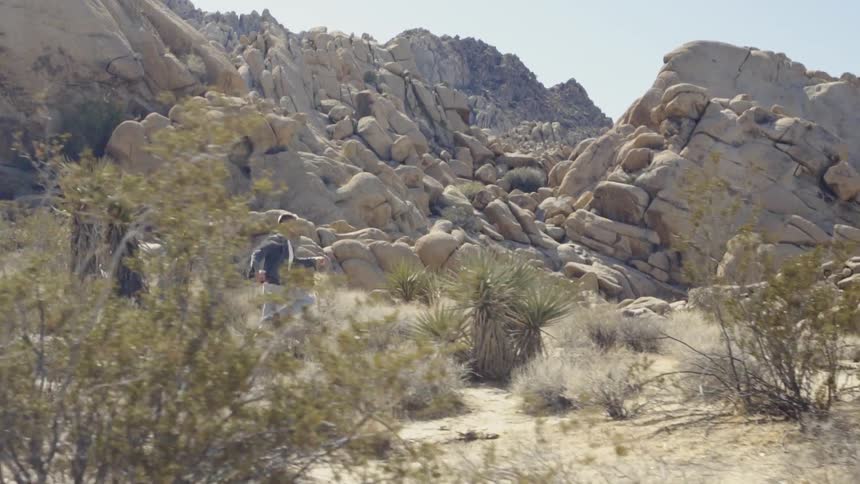 A man running and leaping through the desert