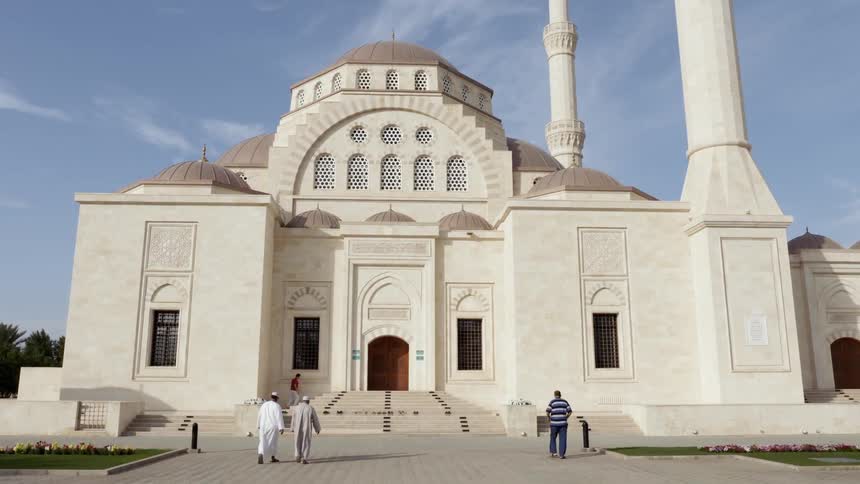 People walking toward a white building