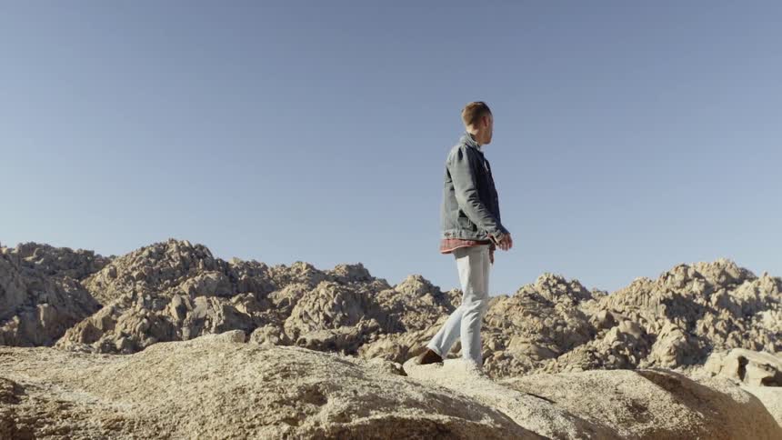 A man is standing on the rocks of the mountain