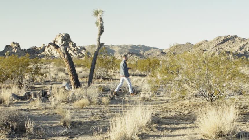 A man walks through an arid landscape
