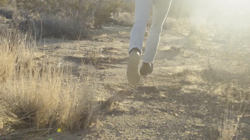 Person running through dirt covered weeds