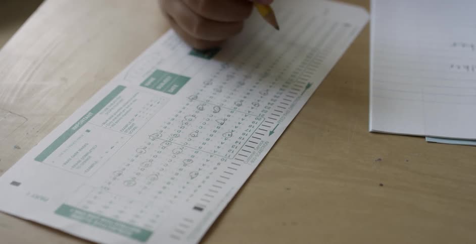 Someone holding a pencil puts it down on a form