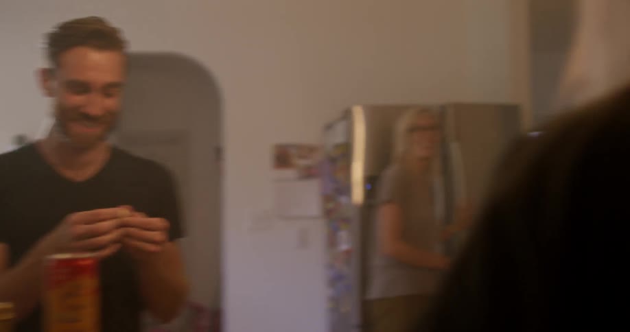 A group of people in a kitchen talking and eating