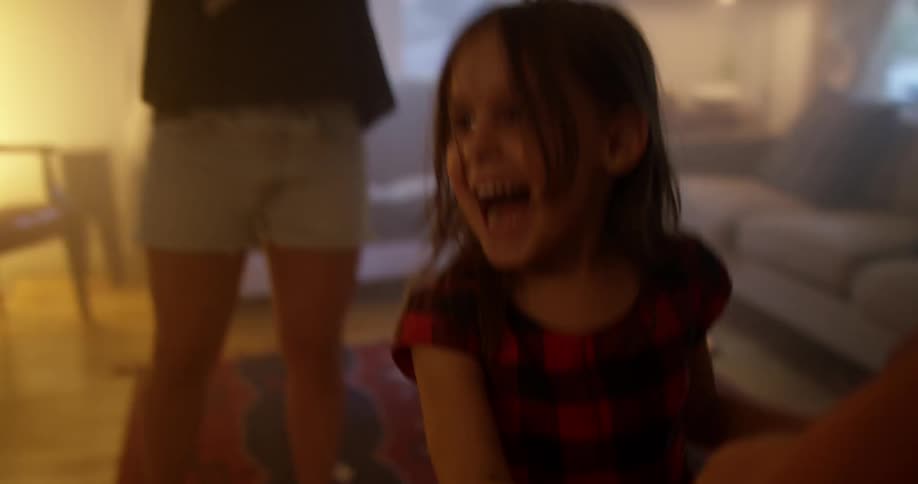 Father plays with his daughter in the living room