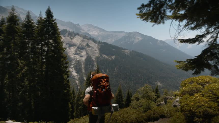 Hiker standing in middle of trail admiring the landscape in the wilderness