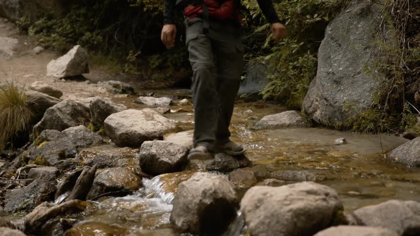 A person walking along a stream