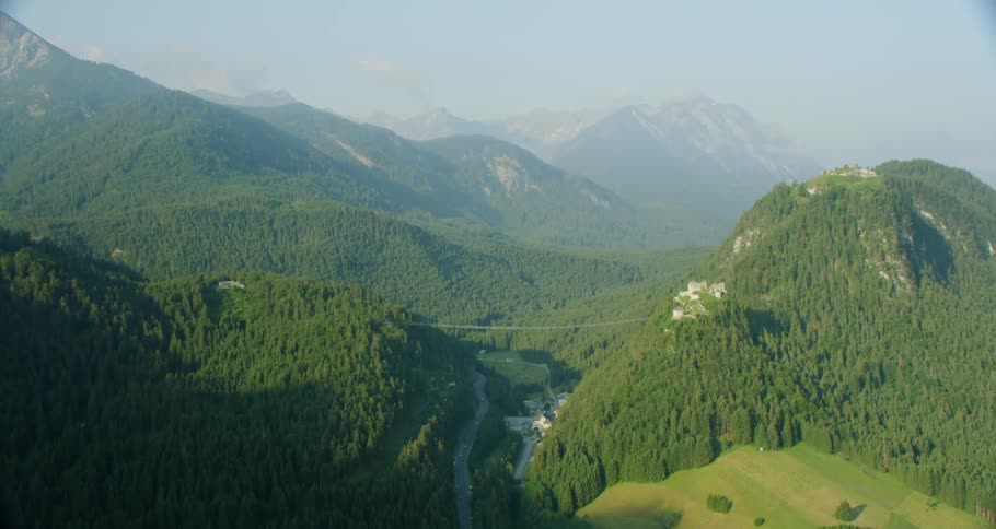 A large suspension bridge is hanging between mountains