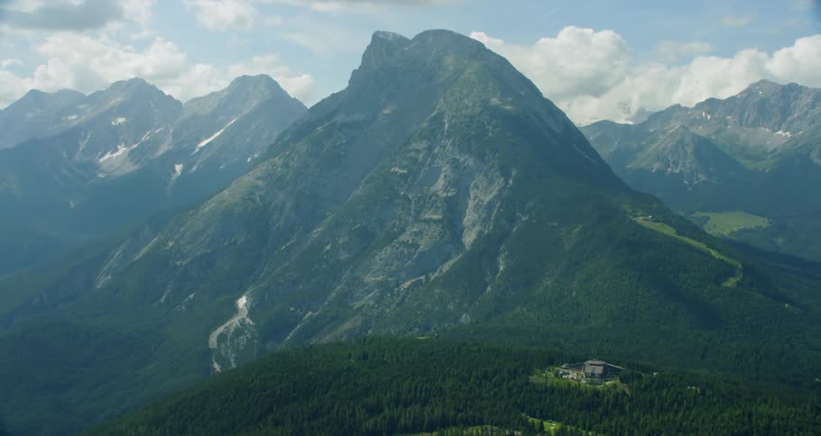 A mountain range envelopes a bright sky
