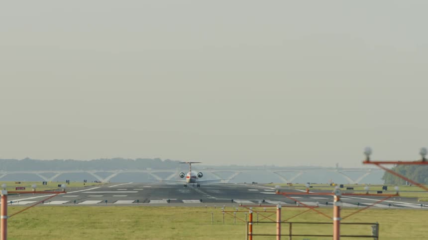 An airplane lands on a rural landing strip