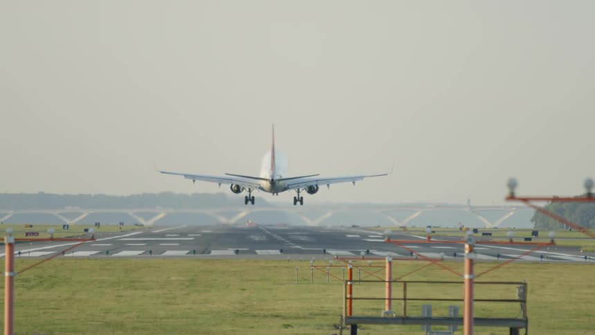 An airplane lands on a rural landing strip
